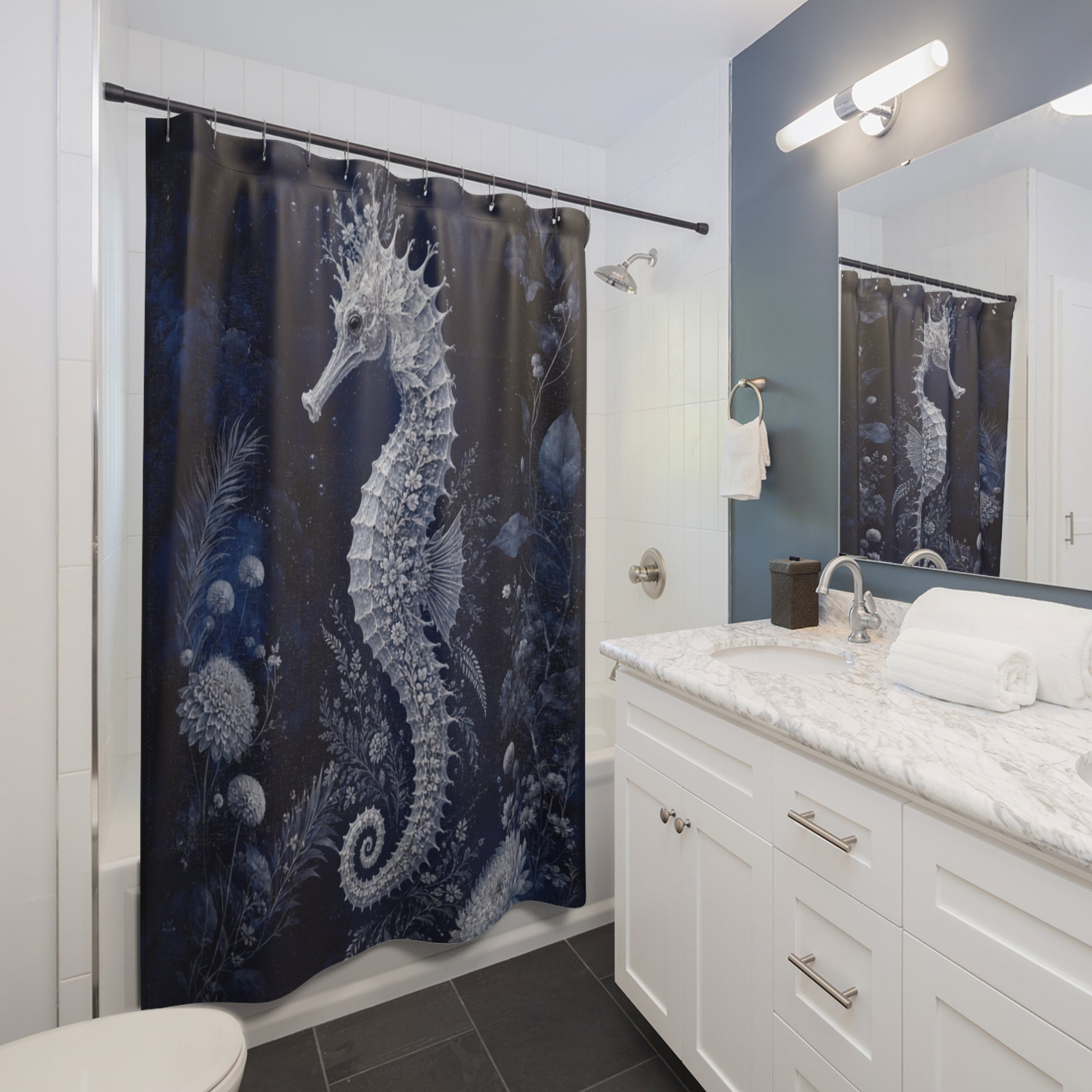 A bathroom scene showing a dark navy shower curtain with a large white seahorse and sea plant print, installed in a bathtub. A white vanity with a marble countertop, mirror, and wall light are visible to the right.