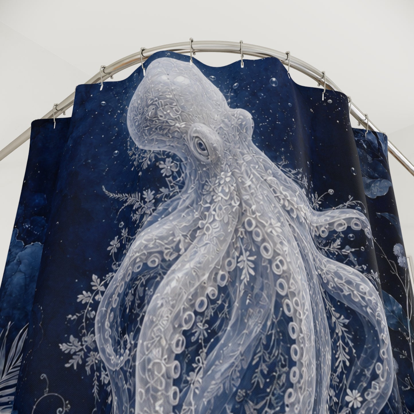 A dark navy blue shower curtain featuring a large white octopus illustration with detailed tentacles and floral sea-plant motifs, hanging from a curved metal rod against a plain light background.