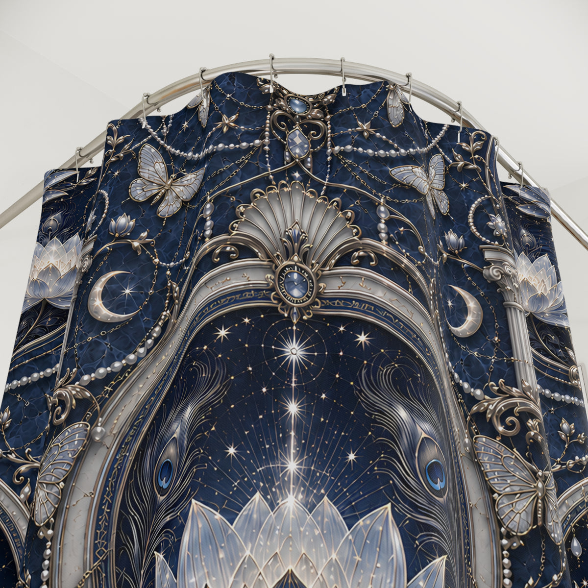 A close-up of an ornate celestial-themed  shower curtain featuring a deep navy blue background with silver-toned filigree, stars, crescent moons, butterflies, and lotus motifs.