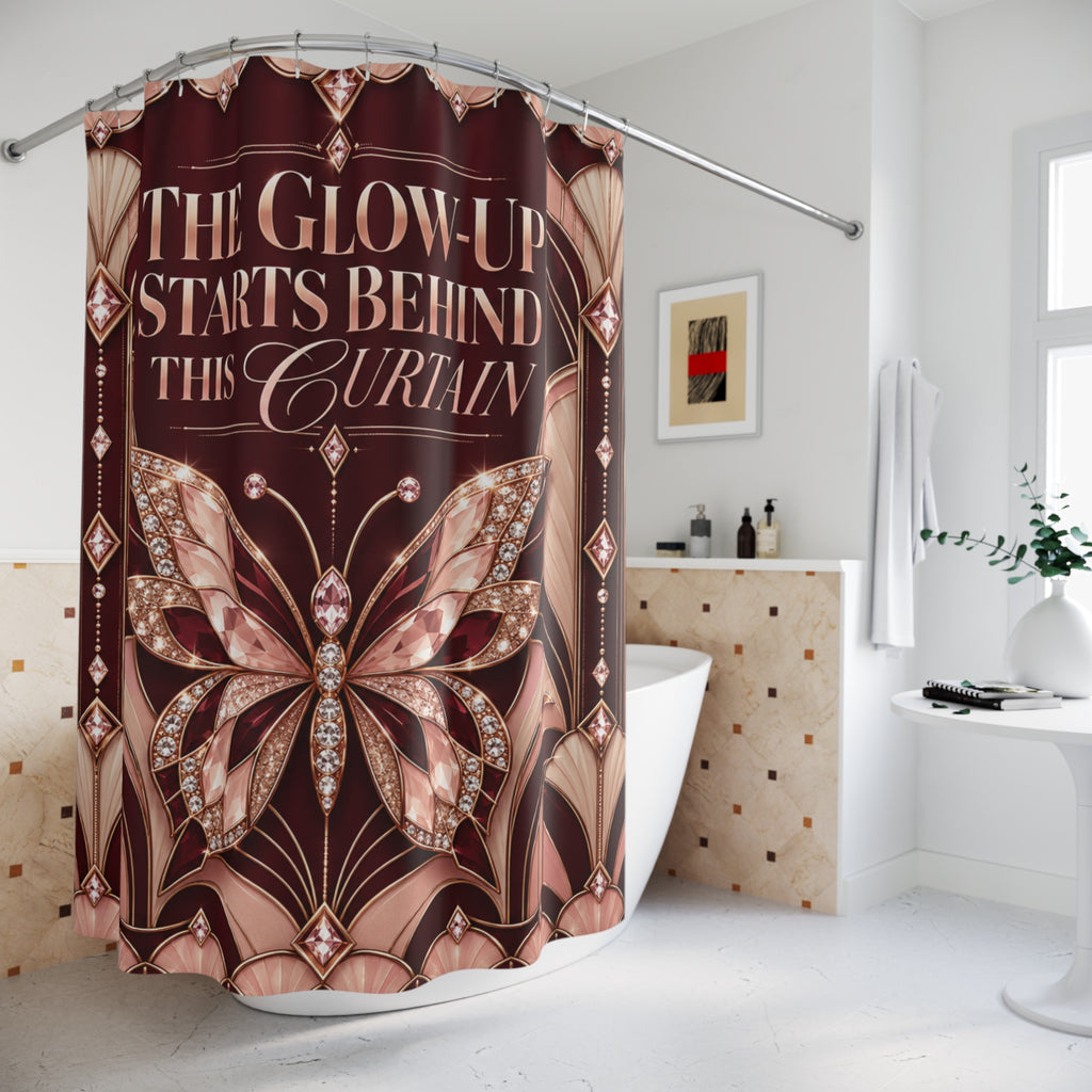 A shower curtain hanging in a bright bathroom, featuring a large butterfly design and the text 'THE GLOW-UP STARTS BEHIND THIS CURTAIN' in a rose-gold and brown palette.