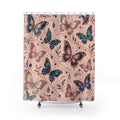 A shower curtain featuring a detailed pattern of colorful butterflies in shades of blue, purple, and pink over a dusty pink background, decorated with delicate gold vine details and small blue gem accents. The curtain is shown hanging from silver rings on a white rod, with the bottom of the curtain resting on a white tub edge.