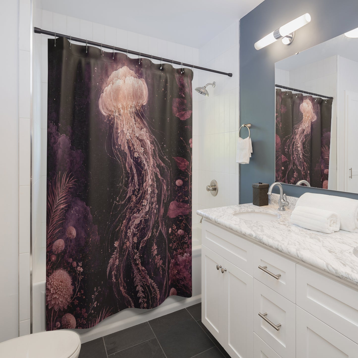 A shower curtain featuring a dark underwater scene with a large pink jellyfish and purple coral, shown hanging in a modern white and blue bathroom with a marble vanity and mirror.