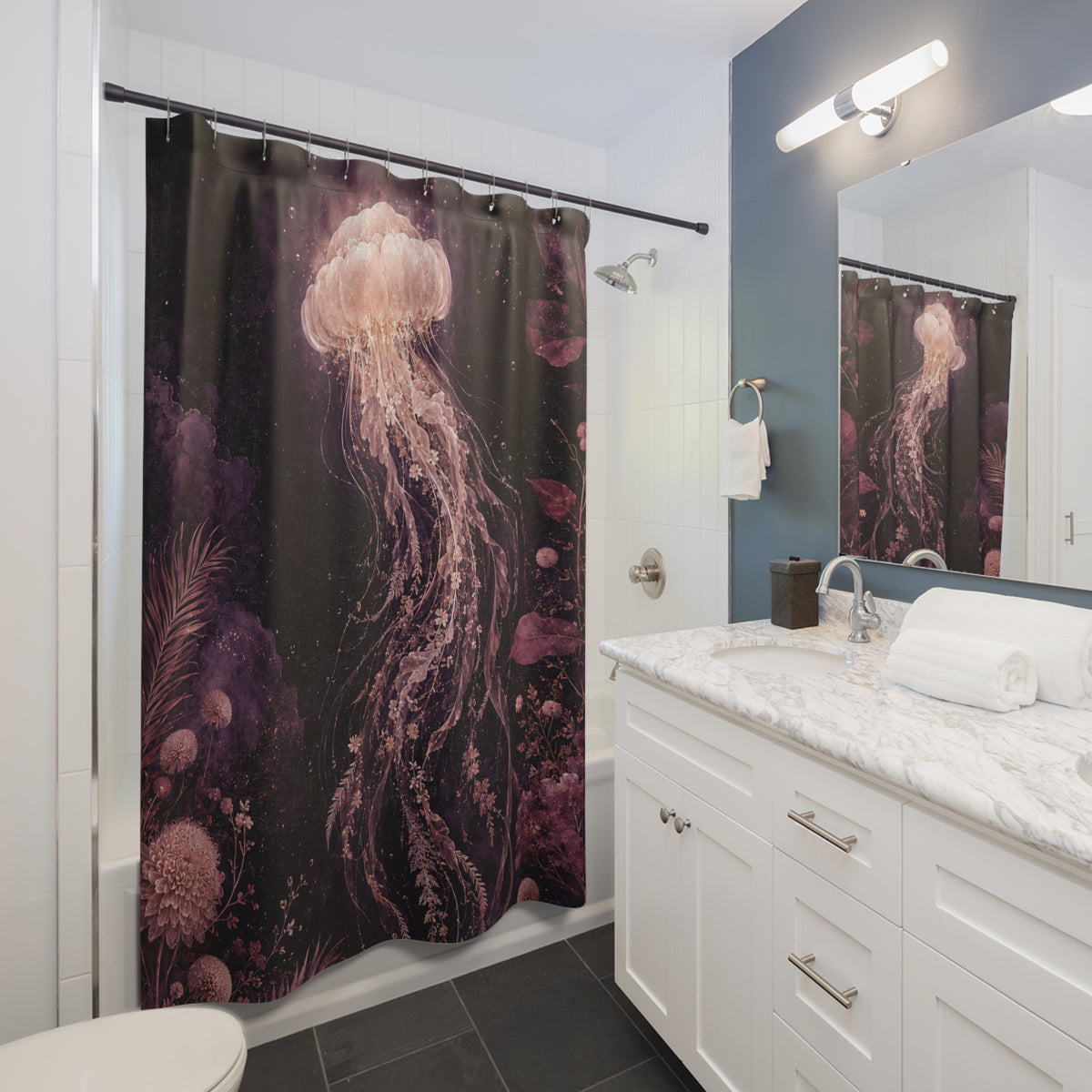 A shower curtain featuring a dark underwater scene with a large pink jellyfish and purple coral, shown hanging in a modern white and blue bathroom with a marble vanity and mirror.