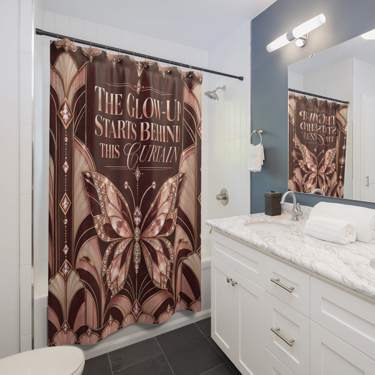 A bathroom scene showing a shower curtain with a large butterfly design and the text 'THE GLOW-UP STARTS BEHIND THIS CURTAIN.' The room includes a white vanity, marble countertop, mirror, and dark blue-gray accent wall.