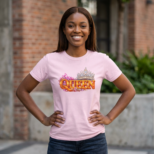 Woman wearing a pink 'QUEEN' t-shirt with a crown graphic, standing outdoors.