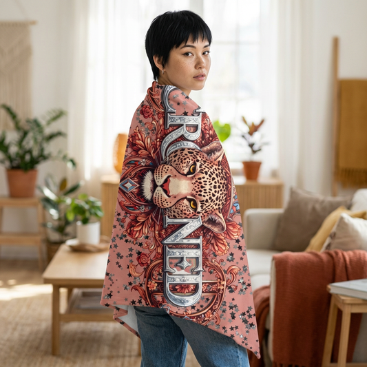 Person wearing a colorful throw blanket with a leopard design in a living room.