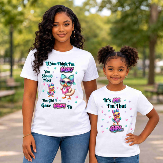 Two people wearing white t-shirts with colorful graphics and text in a park setting.