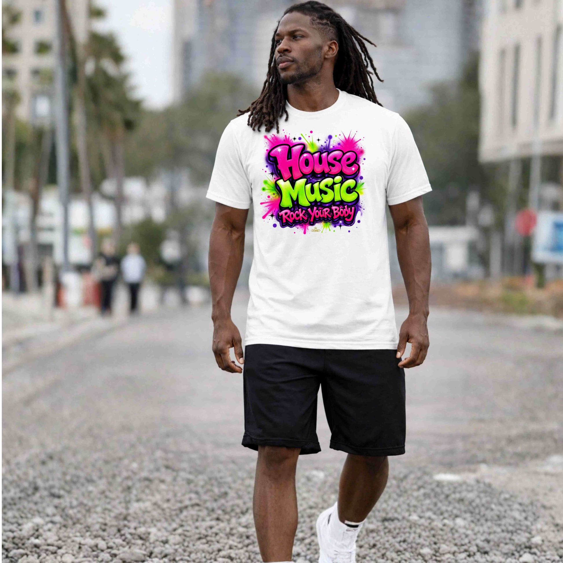 Man wearing a white t-shirt with 'House Music' text walking on a street.