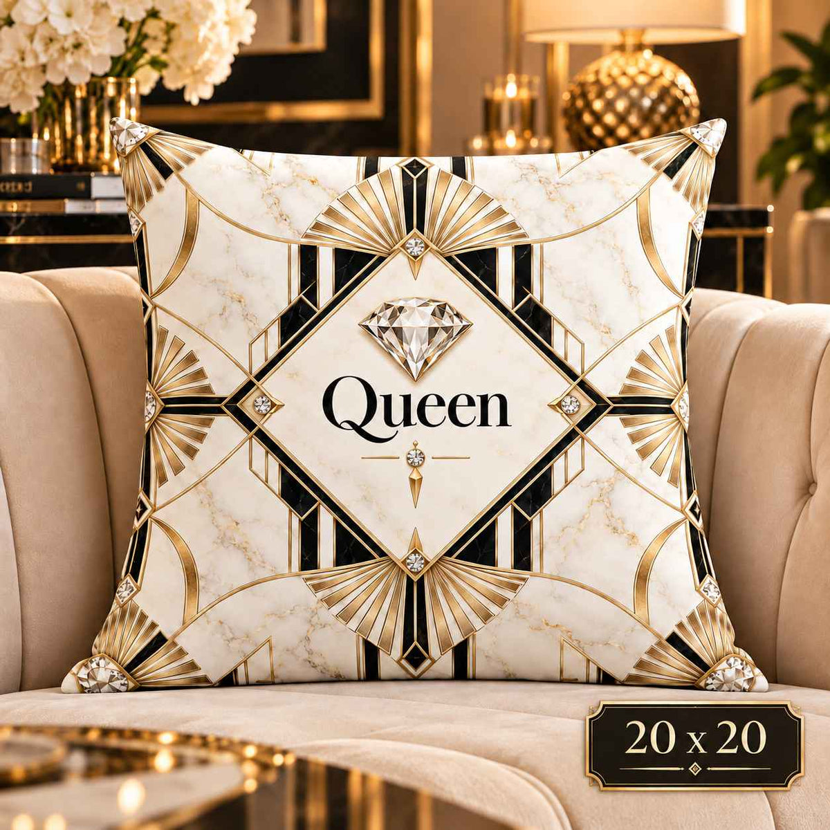 A square decorative throw pillow with an Art Deco-inspired design featuring a cream marble background, gold geometric fan patterns, black lines, and a central diamond graphic with the word 'Queen' in script. The pillow is styled on a beige armchair in a luxurious, high-end living room setting with gold furniture and flowers in the background.