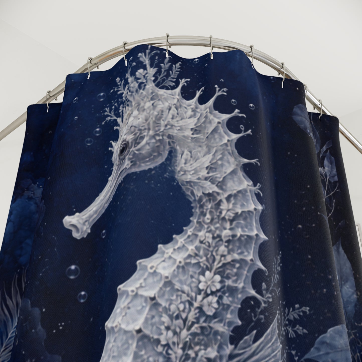A dark navy blue shower curtain featuring a large white seahorse illustration with delicate floral details, hanging from a curved metal rod against a light background.