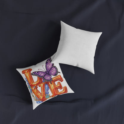 Decorative pillow with 'LOVE' and butterfly design on a dark fabric background