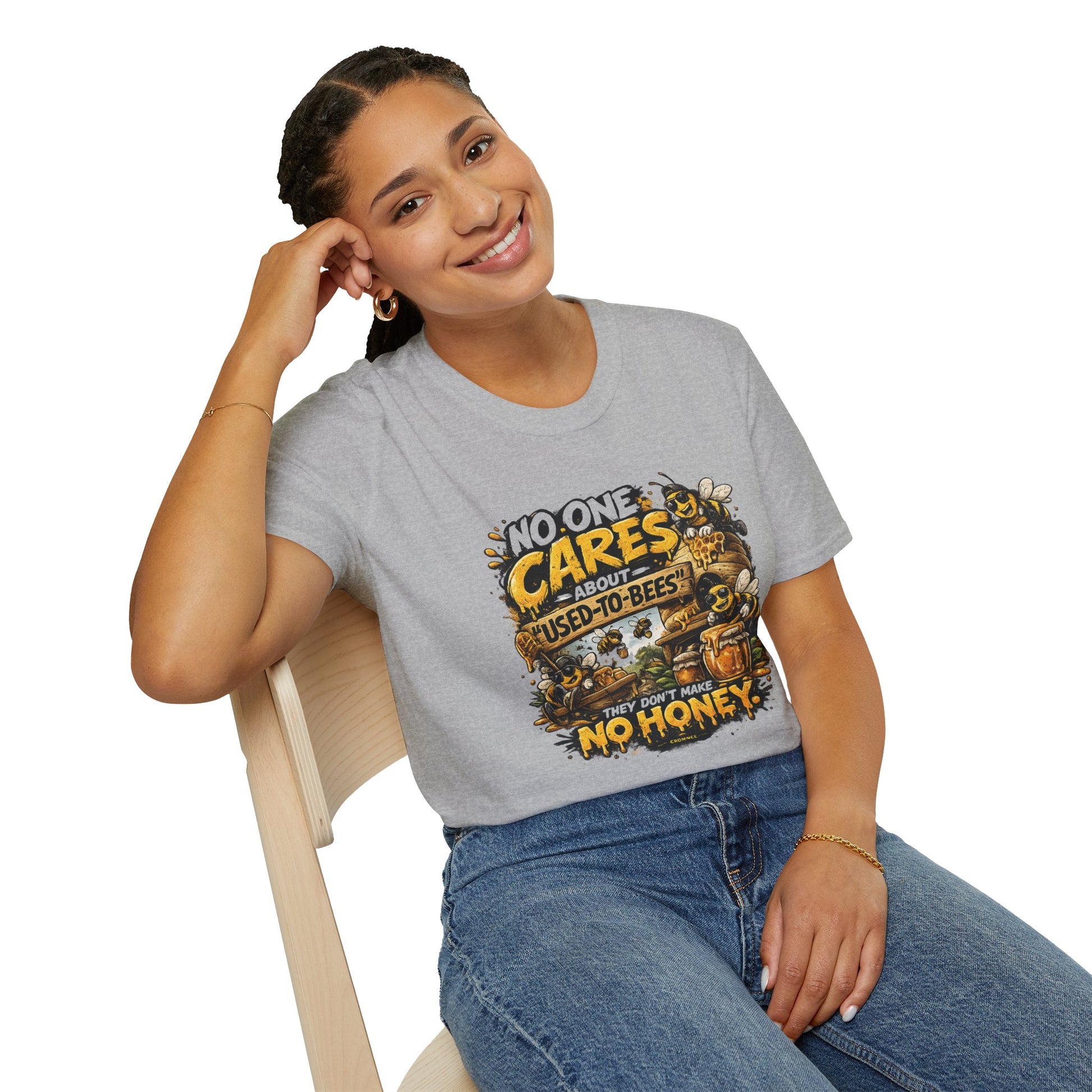 Person wearing a gray t-shirt with a graphic design sitting on a chair.
