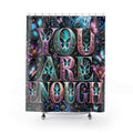 A shower curtain featuring the phrase 'YOU ARE ENOUGH' in large decorative letters filled with butterfly and floral artwork, shown hanging against a plain white background.