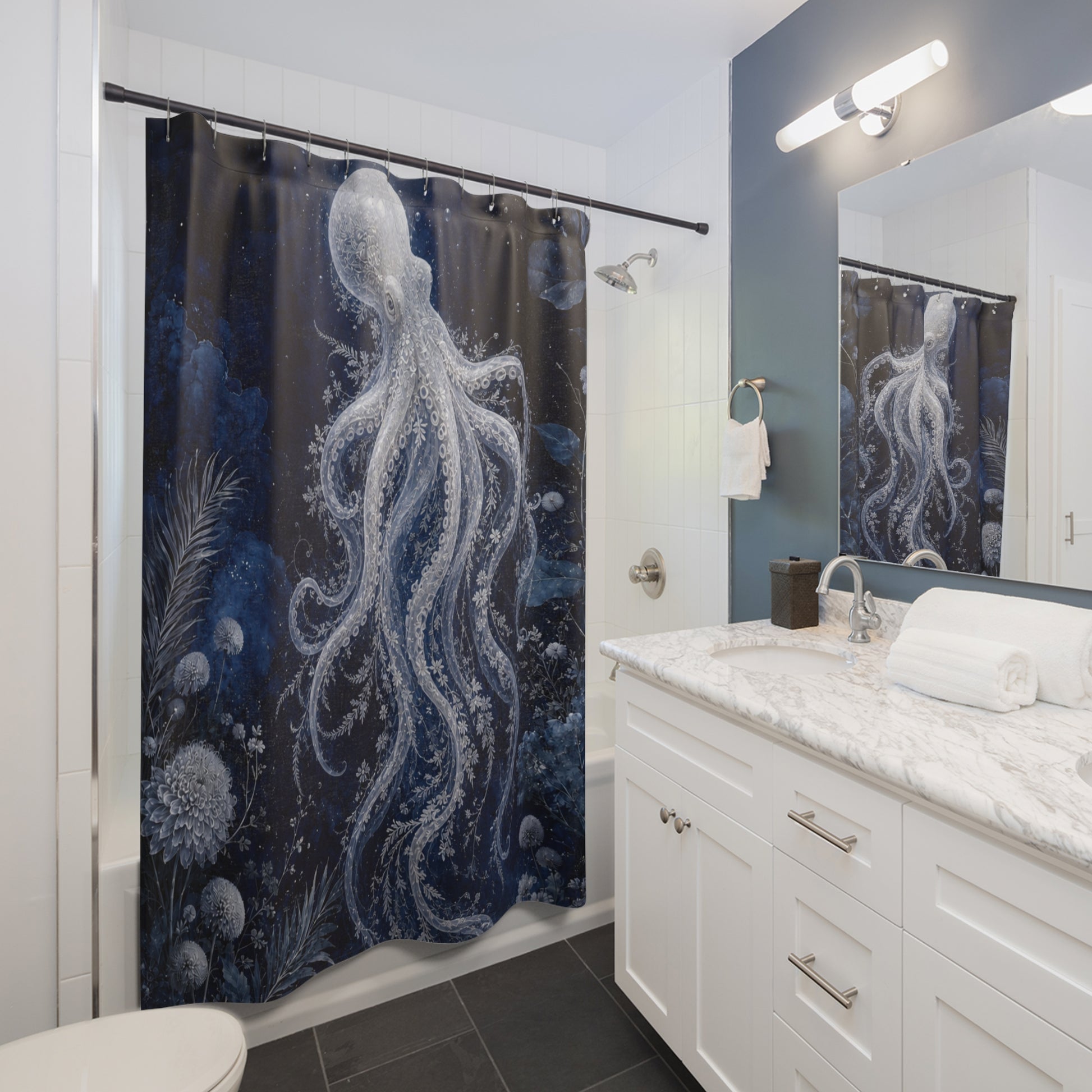 A dark blue and black shower curtain featuring a large white octopus and sea foam print, hanging in a modern white bathroom with a marble vanity and mirror.