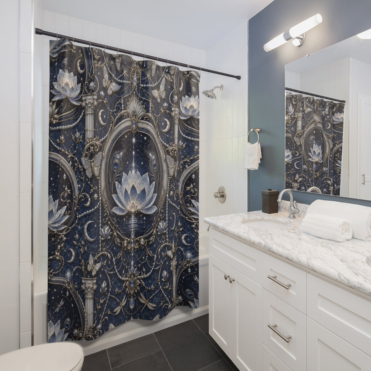 A bathroom scene showing a shower curtain with an ornate navy, silver, and white baroque-style floral pattern, installed in a modern white and blue bathroom with a marble countertop and mirror.