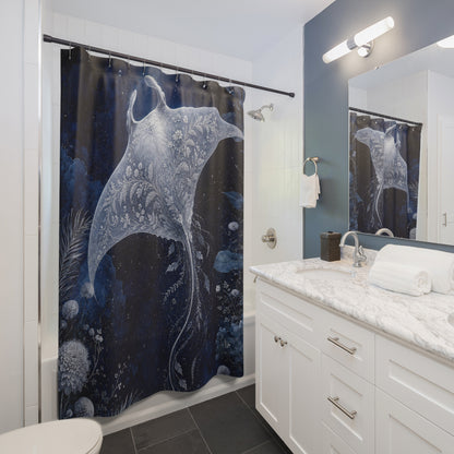 A bathroom scene showing a shower curtain with a large white manta ray and underwater sea plant print on a dark navy background. The bathroom includes a white vanity with a marble countertop, a mirror, and a wall-mounted light fixture.