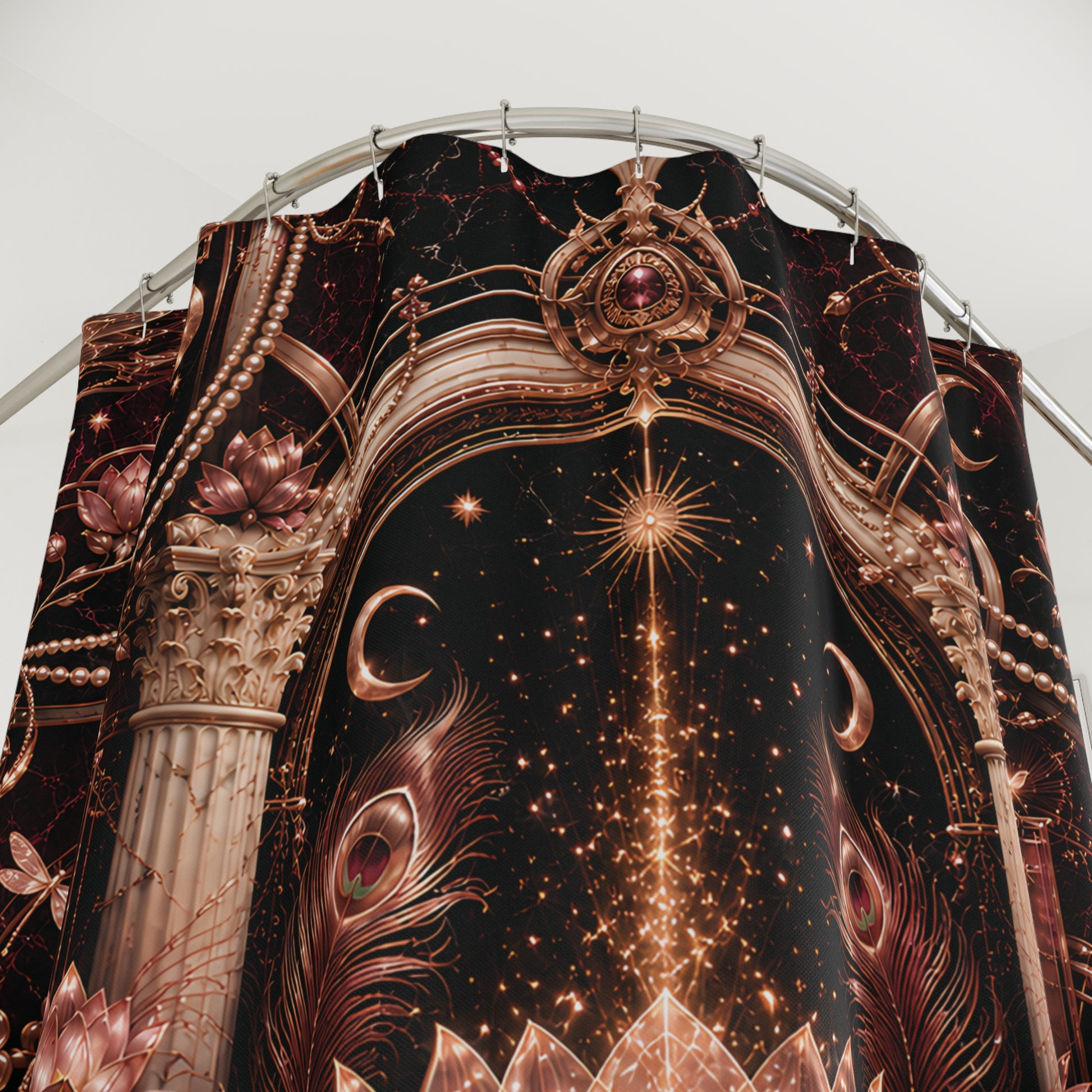 A close-up of a draped shower curtain y featuring an ornate celestial and architectural print. The design has a black background with metallic bronze-gold stars, crescent moons, peacock feathers, lotus flowers, and classical columns, hanging from a curved metal rod against a plain light gray background.