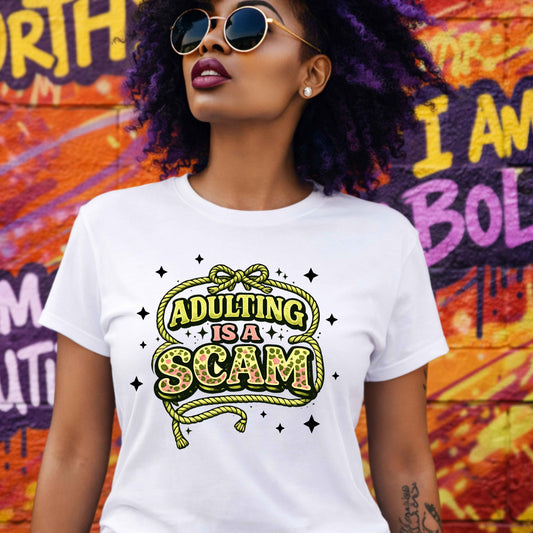 Person wearing a white t-shirt with 'ADULTING IS A SCAM' text in front of a colorful mural.